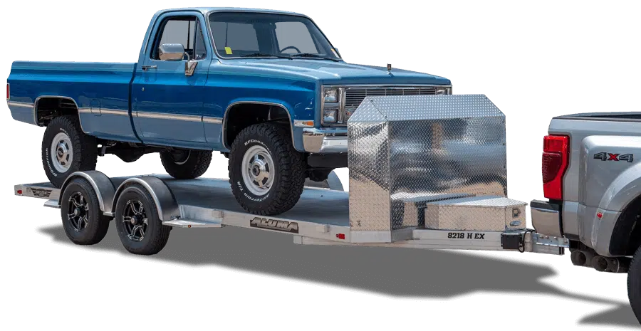 aluma trailer with rock gaurd has a classic truck being pulled by a modern truck